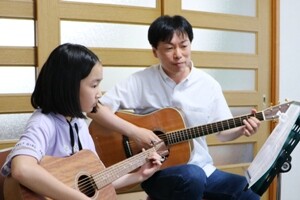 アコースティックギターを弾く小学生の女の子